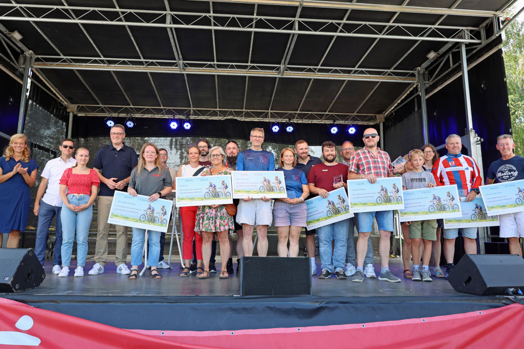 Menschen stehen mit Urkunden auf eienr Bühne.