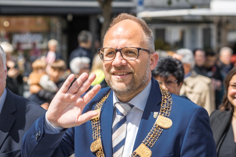 Bürgermeister Roger Nießen winkt während des Festzugs.