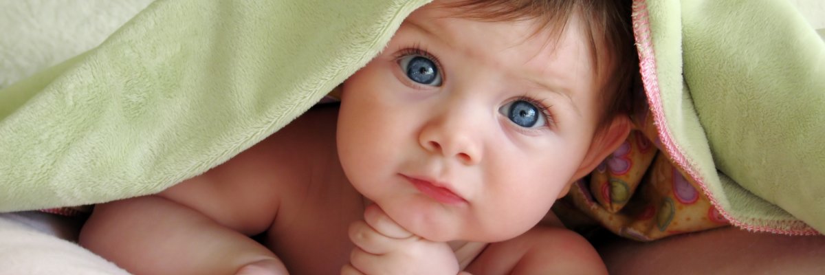 Ein süßes Baby blickt den Betrachter an.