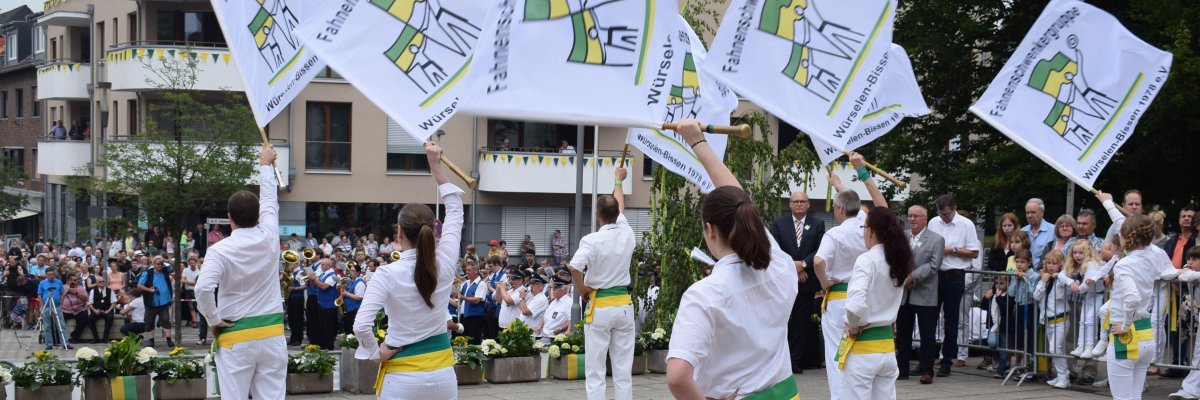 Fahnenschwenken am Dom Einige Menschen schwenken eine Fahne vor Zuschauern