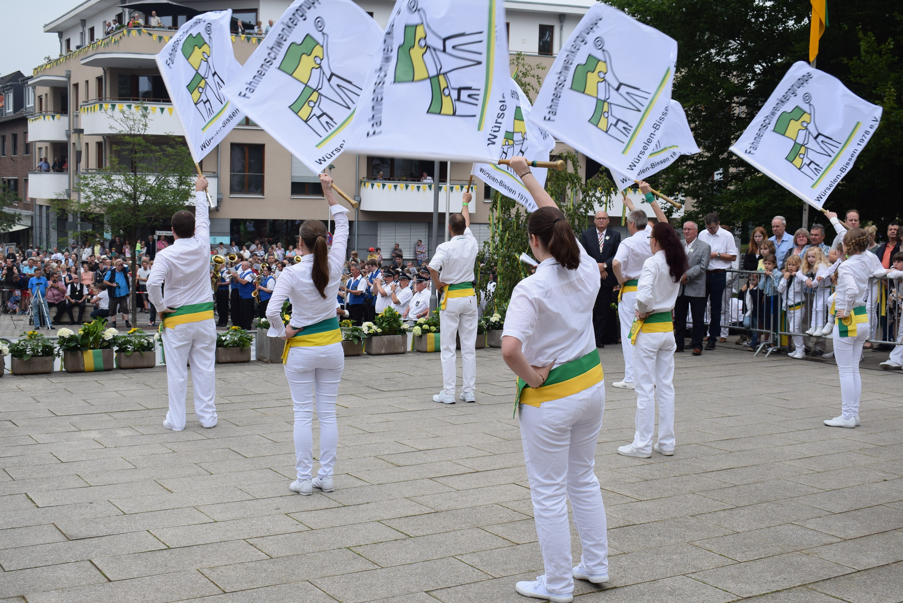 Einige Menschen schwenken eine Fahne vor Zuschauern