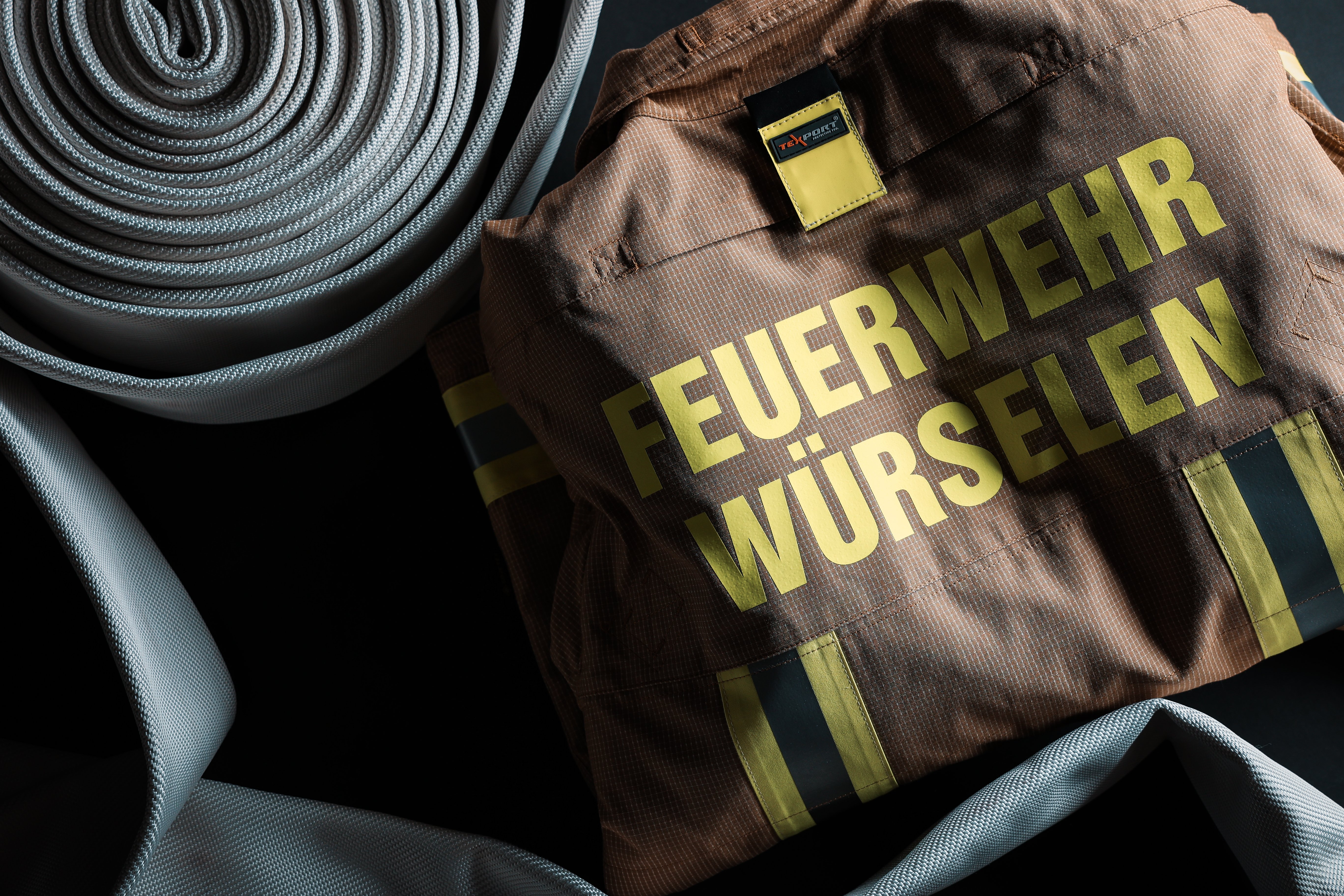 Ein Schlauch und eine Feuerwehruniform mit der Aufschrift Feuerwehr Würselen