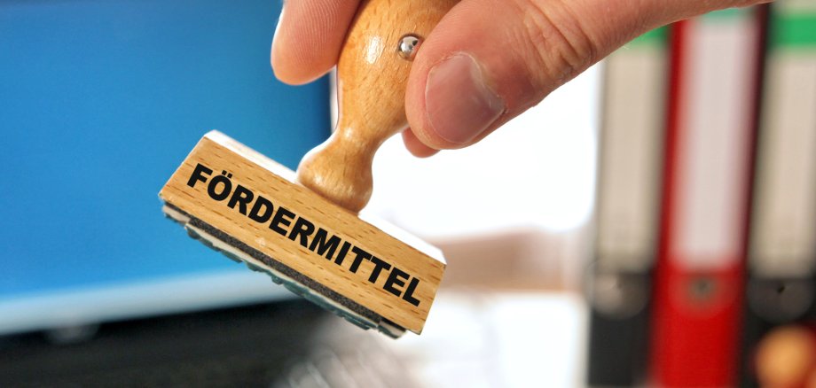 Fördermittel Fördermittelstempel und Hand.