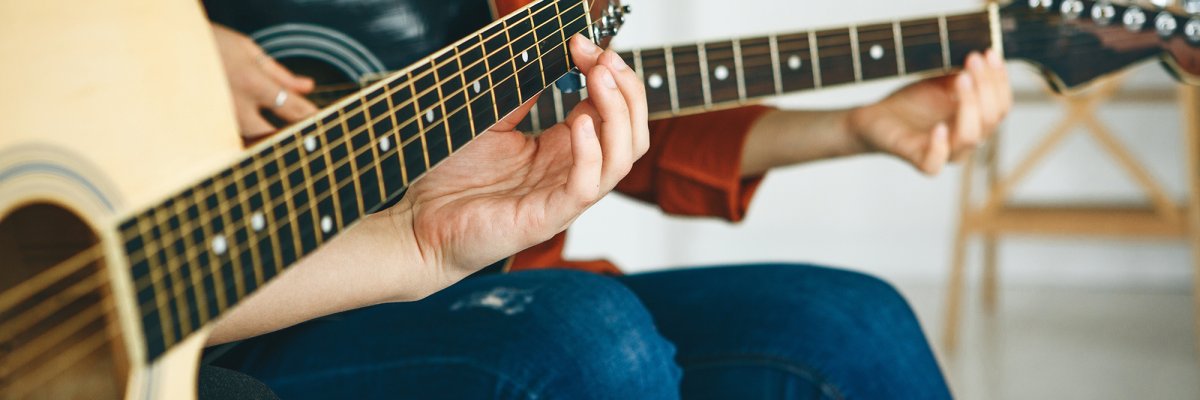 Musikschule Gitarrenunterricht. Lehrer erklärt dem Schüler an der Gitarre die Griffe.