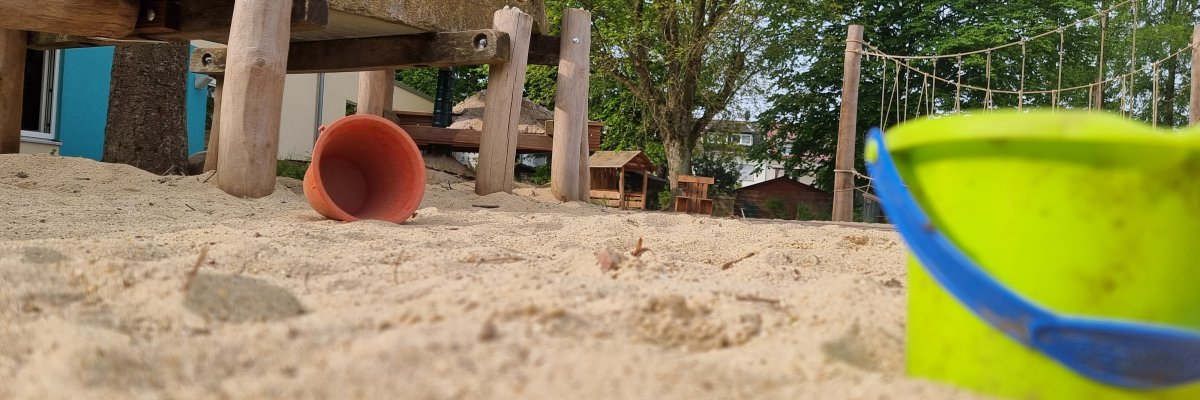 Eimer und Sandspielzeug in einem Sandkasten