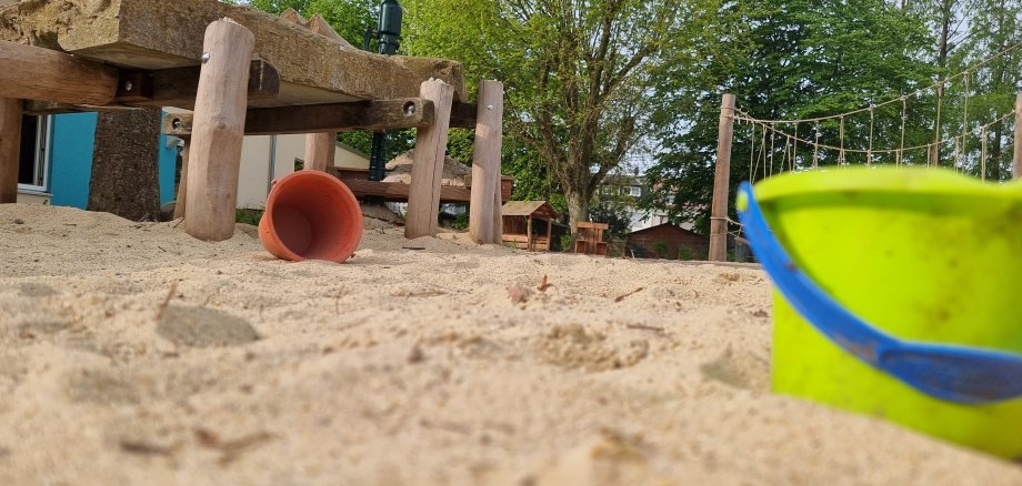 Eimer und Sandspielzeug in einem Sandkasten