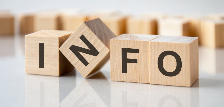four wooden blocks with the letters info on the bright surface of a gray table, business concept Vier Würfel mit den Buchstaben I N F O