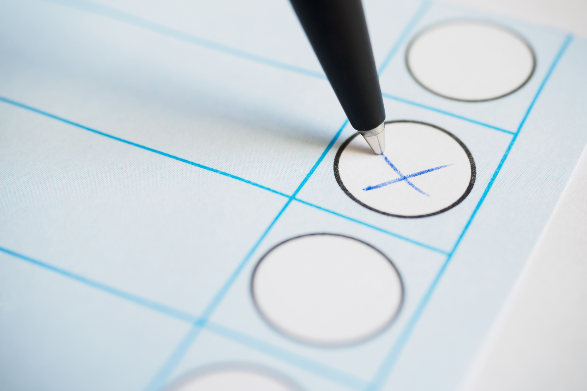 Ein Kuli markiert einen Stimmzettel mit einem Kreuz.