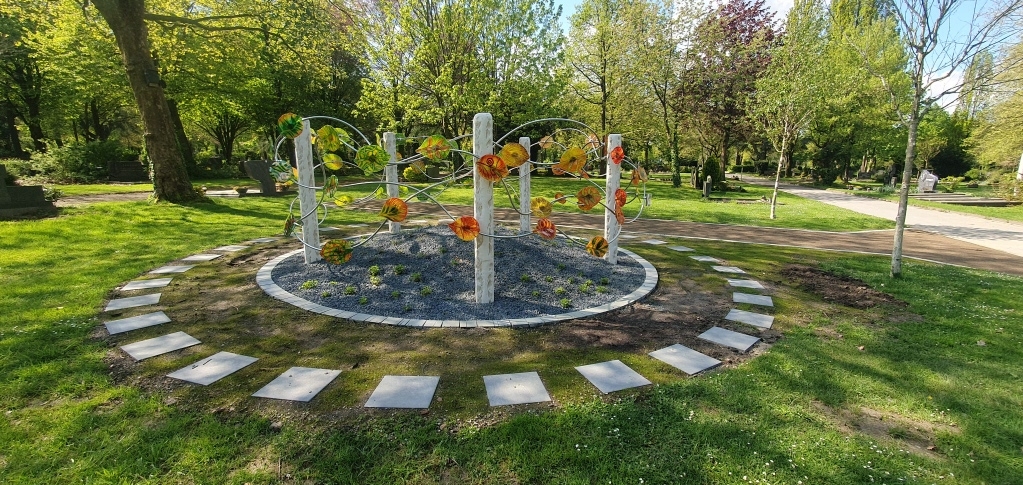 Kreis mit Metallkonstruktion, daran bunte Metallblätter.