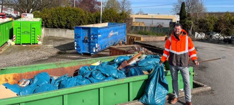 Enrico Jansen steht vor dem Abfallcontainer mit dem gesammelten Abfall.