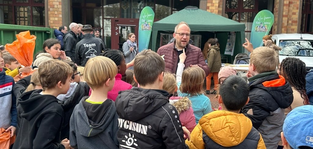 Bürgermeister Roger Nießen umringt von Kindern vor dem Rathaus.
