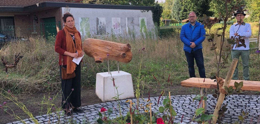 Ein Mann arbeitet an einem neuen Staudenbeet mit einer Bank