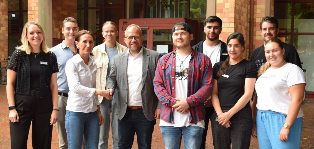 Die neuen Auszubildenden stehen zusammen mit Bürgermeister Roger Nießen vor dem Rathaus.