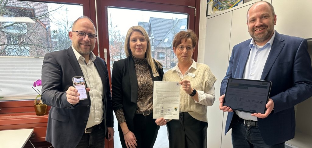 Bürgermeister Roger Nießen und seine Mitarbeiter und Mitarbeiterinnen halten das Handy in die Kamera.