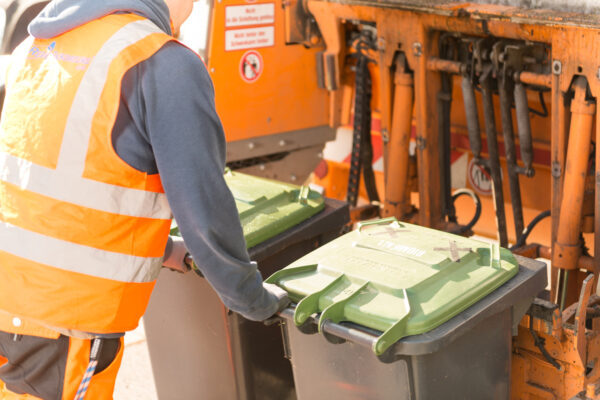 Müllfahrzeug mit zwei Biotonnen und einem Mitarbeiter