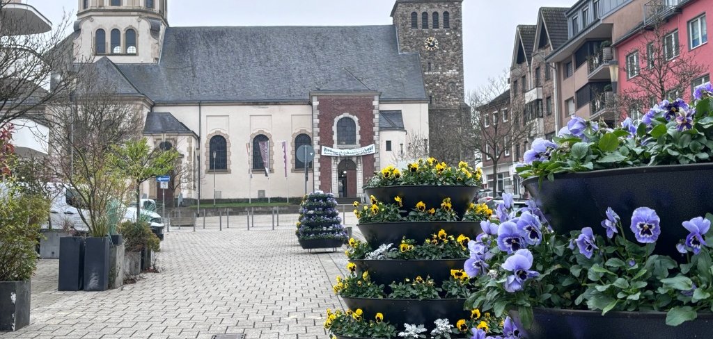 Blumenkaskaden bunt bepflanzt im Hintergrund der Würselener Dom.