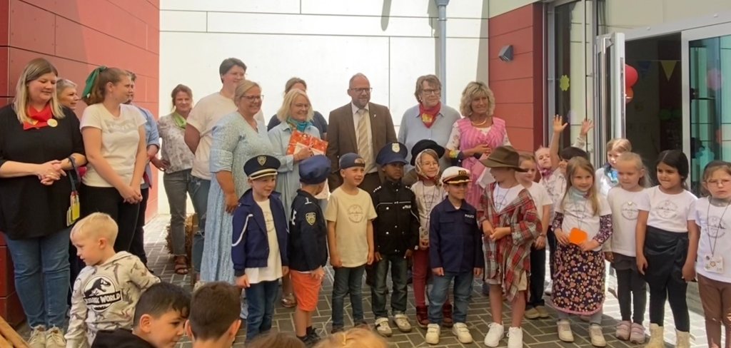 Bürgermeister Nießen mit vielen Gästen und Kindern vor dem Kindergarten.