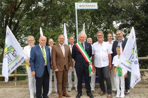 Bürgermeister Roger Nießen steht mit einigen Würselenern und mit seinen italienischen Freunden vor dem Würselen-Platz in Campaagnatico.