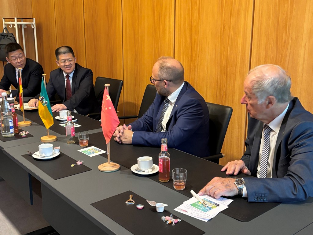 Vier Männer sitzen an einem Tisch und unterhalten sich.