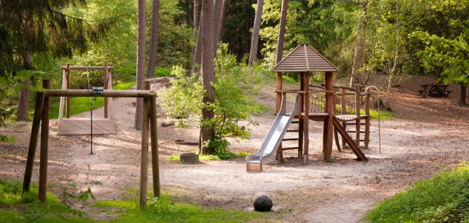 Waldspielplatz mit großem Spielturm.