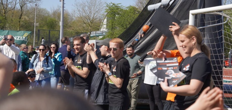 Helfer beim Event verteilen Urkunden.