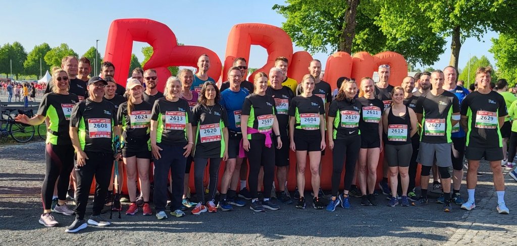 Gruppenfoto B2Run 2025 Alle Läuferinnen und Läufer der Stadt Würselen 2025 stehen zusammen vor dem Schriftzug "B2Run"