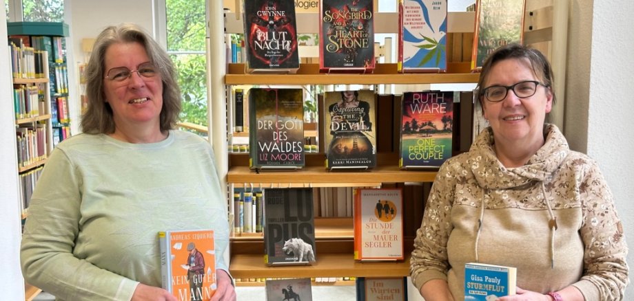Monika Silberer und Lisbeth Olbertz vor dem Bücherregal der Neuerungen.