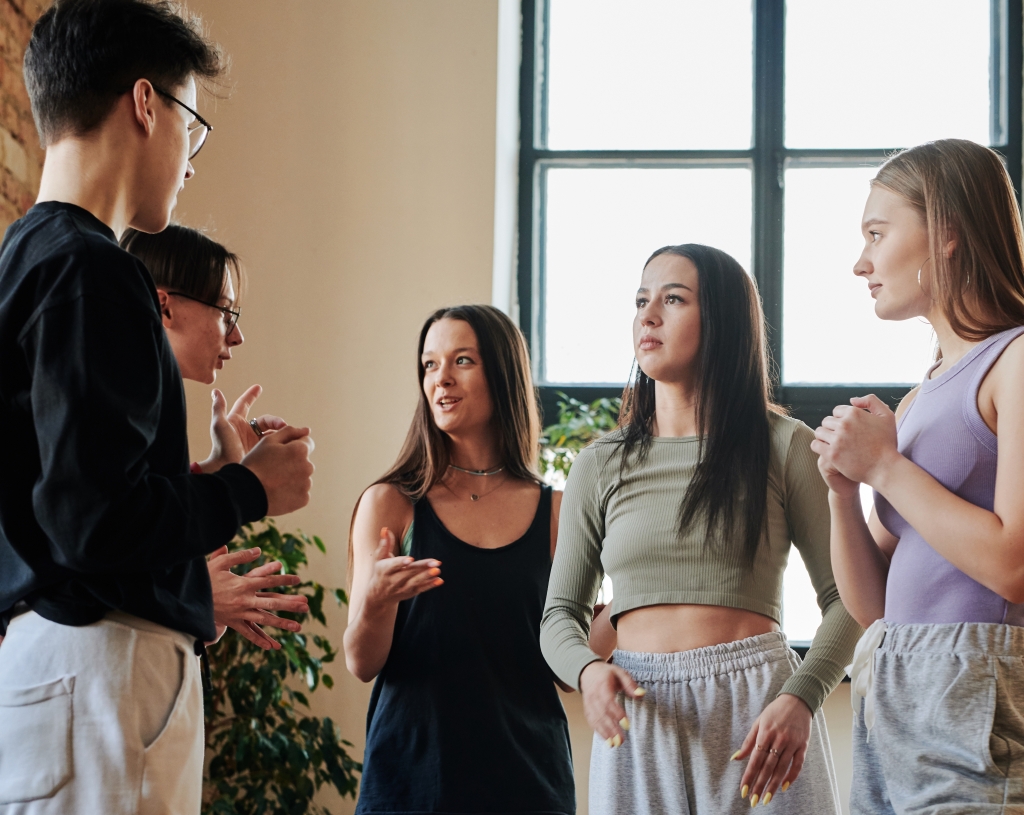Large group of friendly teenagers in activewear communicating in dance studio Jugendliche in der Diskussion