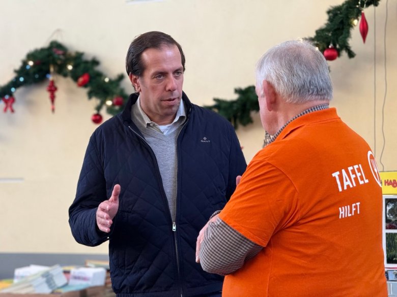 Der Erste Beigeordnete der Stadt Würselen, Marius Claßen, bespricht die Aktion mit Helfer:innen der Tafel und freut sich über das große Engagement.