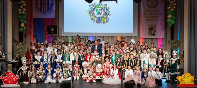 Zahlreichen Kinder in Karnevalsuniformen gemeinsam auf einer Bühne