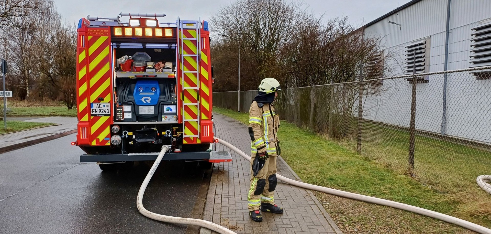 Ein Feuerwehrauto und ein Feuerwehrmann am Straßenrand