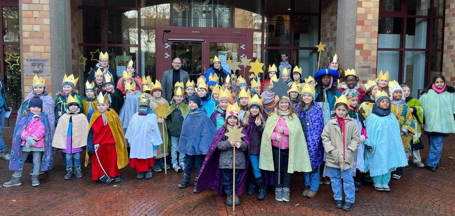 Zahlreiche Kinder als Sternsinger stehen zusammen mit dem Bürgermeister vor dem Rathaus