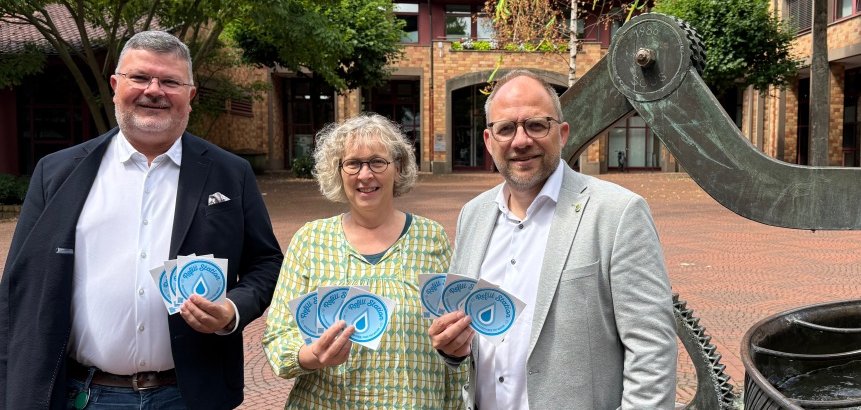 Refill in Würselen Drei Personen zeigen Aufkleber