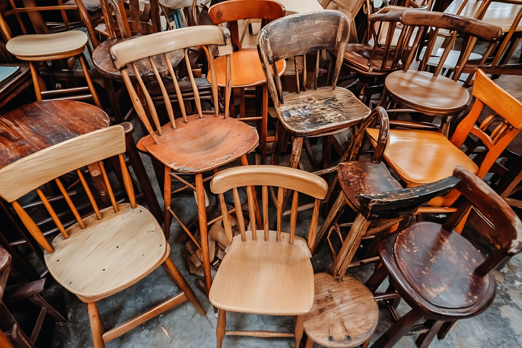 Vintage Wooden Chairs Pile: Rustic Textures and Worn Patina Möbel für Flohmarkt.
