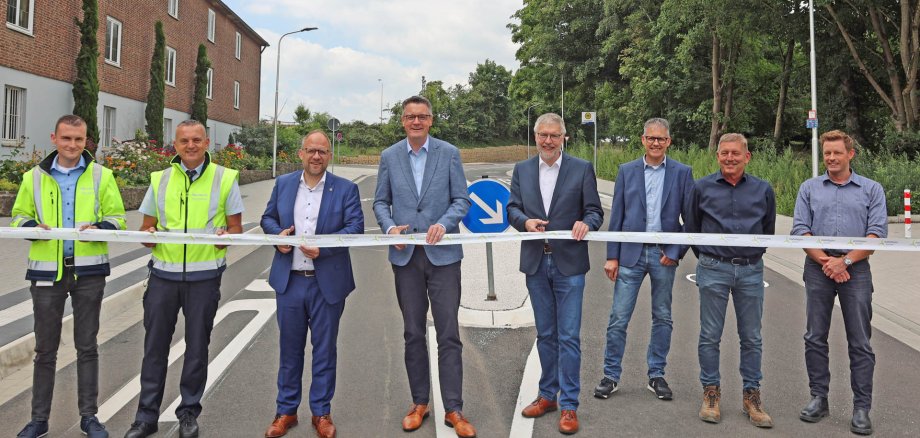 Städteregionsrat Dr. Tim Grüttemeier (4. v. l.), Würselens Bürgermeister Roger Nießen (3. v. l.) und der Schulleiter des Heilig-Geist-Gymnasiums, Christoph Barbier (4. v. r.) beim feierlichen Banddurchschnitt – gemeinsam mit Vertretern der ASEAG, des Tiefbauamtes der Stadt Würselen, des Ingenieurbüros Quadriga, der Firma Blandfort Bau GmbH & Co. KG sowie Mitarbeitenden des Amtes Raum, Mobilität, Klima der StädteRegion Aachen.
