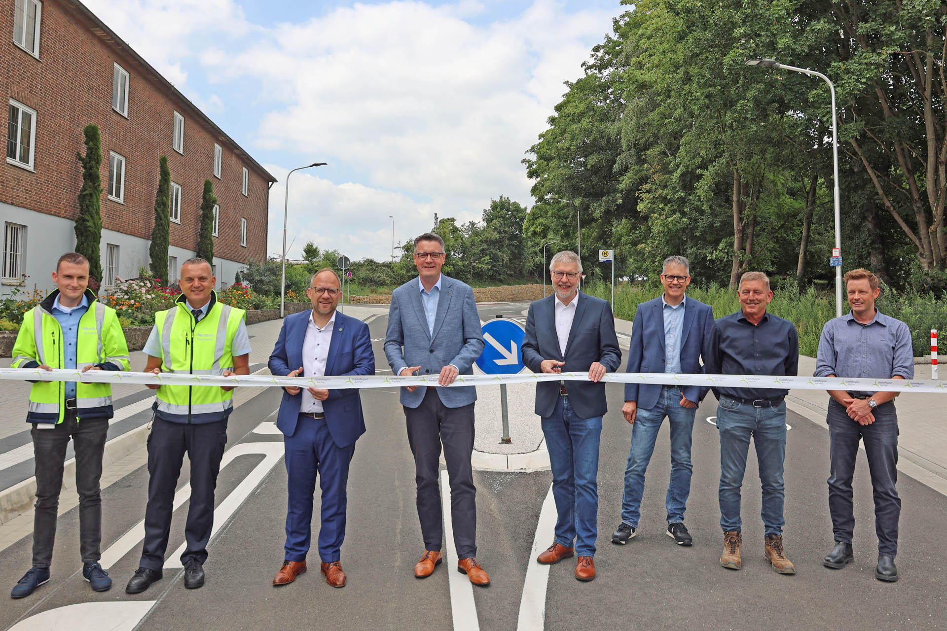 Städteregionsrat Dr. Tim Grüttemeier (4. v. l.), Würselens Bürgermeister Roger Nießen (3. v. l.) und der Schulleiter des Heilig-Geist-Gymnasiums, Christoph Barbier (4. v. r.) beim feierlichen Banddurchschnitt – gemeinsam mit Vertretern der ASEAG, des Tiefbauamtes der Stadt Würselen, des Ingenieurbüros Quadriga, der Firma Blandfort Bau GmbH & Co. KG sowie Mitarbeitenden des Amtes Raum, Mobilität, Klima der StädteRegion Aachen.