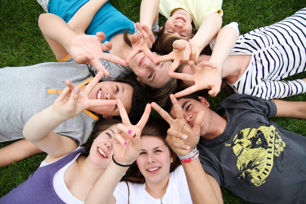 Kinder liegen auf dem Rücken und halten ihre Finger sternförmig nach oben