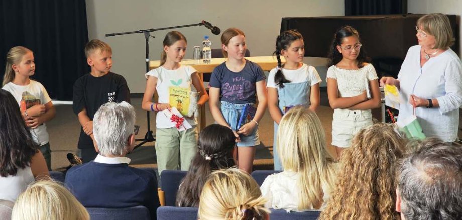 Sechs Kinder stehen auf der Bühne.
