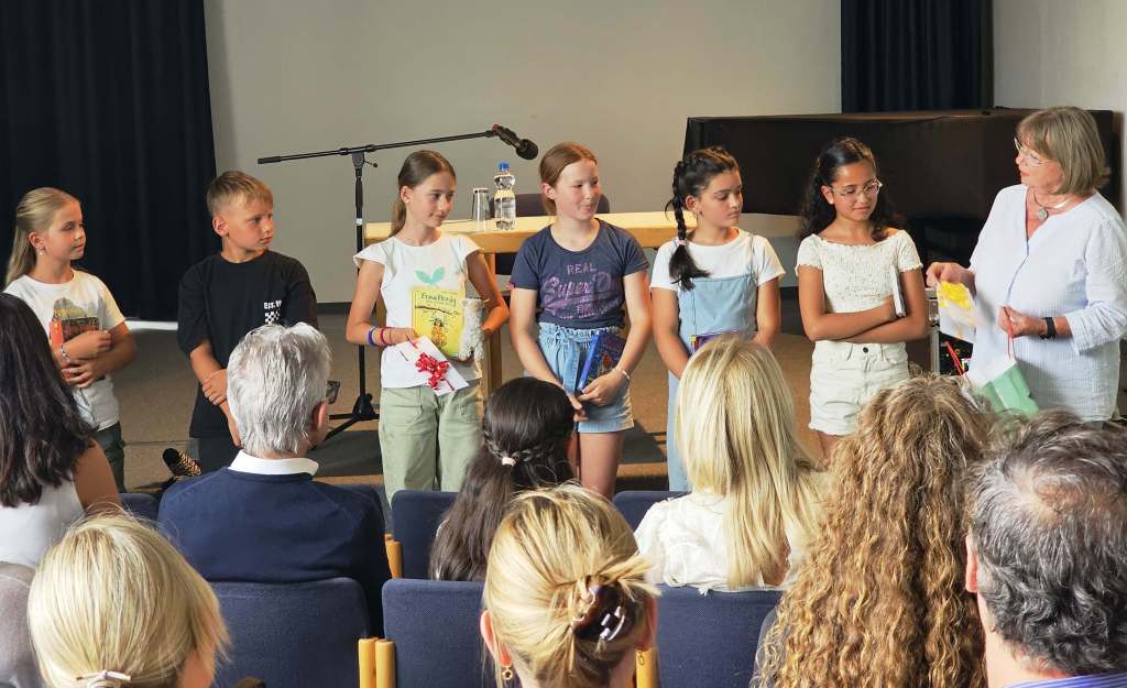 Sechs Kinder stehen auf der Bühne.