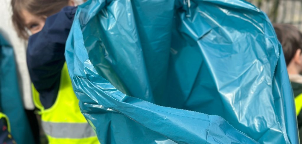 Ein Kind hält eine Mülltüte fest