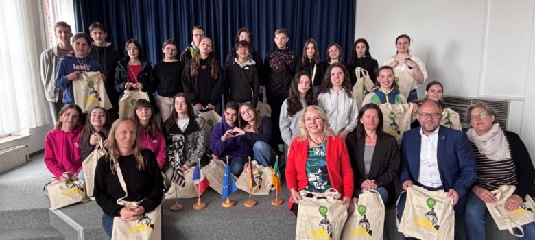 Französische Schüler im Alten Rathaus Schüler und Erwachsene stehen zusammen auf einer Bühne.