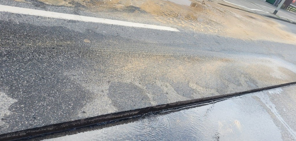 Die Fahrbahndecke ist gespalten, Wasser sickert ein.