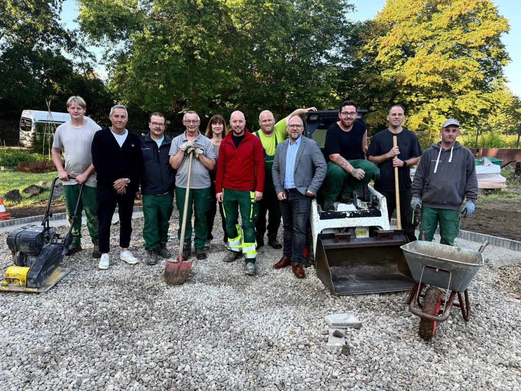 Immer gerne bei der Arbeit und gut gelaunt: Die Mitarbeitenden der Gartengruppe mit ihren Fachanleitern, Stephan Heinrichs und Oliver Rohner (3. und 6. v. l.) zeigen ihre geleisteten Arbeiten dem Betriebsleiter der CBW, Jochen Jung (2. v. l.), und Bürgermeister Nießen (4. v. r.).