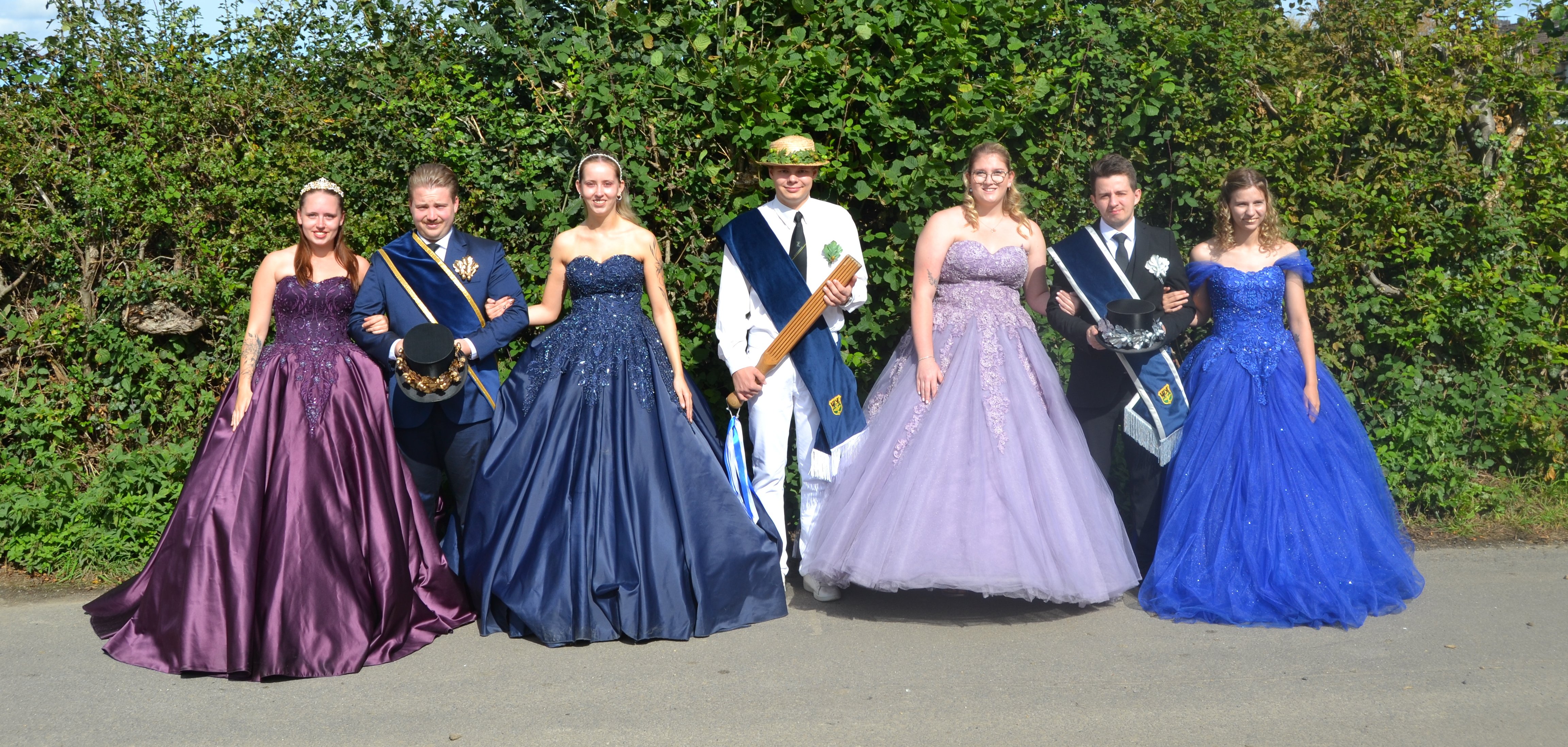 Maikönigin Saskia Wego, Maikönig Pascal Peters, 1. Ehrendame Lea Wego, Pritschenmeister Paul Hermanns, Maimagd Tamara Jüttemann, Maiknecht Jerome Wertz, 2. Ehrendame Catherine Wertz (v.l.). Junge Frauen in Ihren Jungenspiel Kleidern