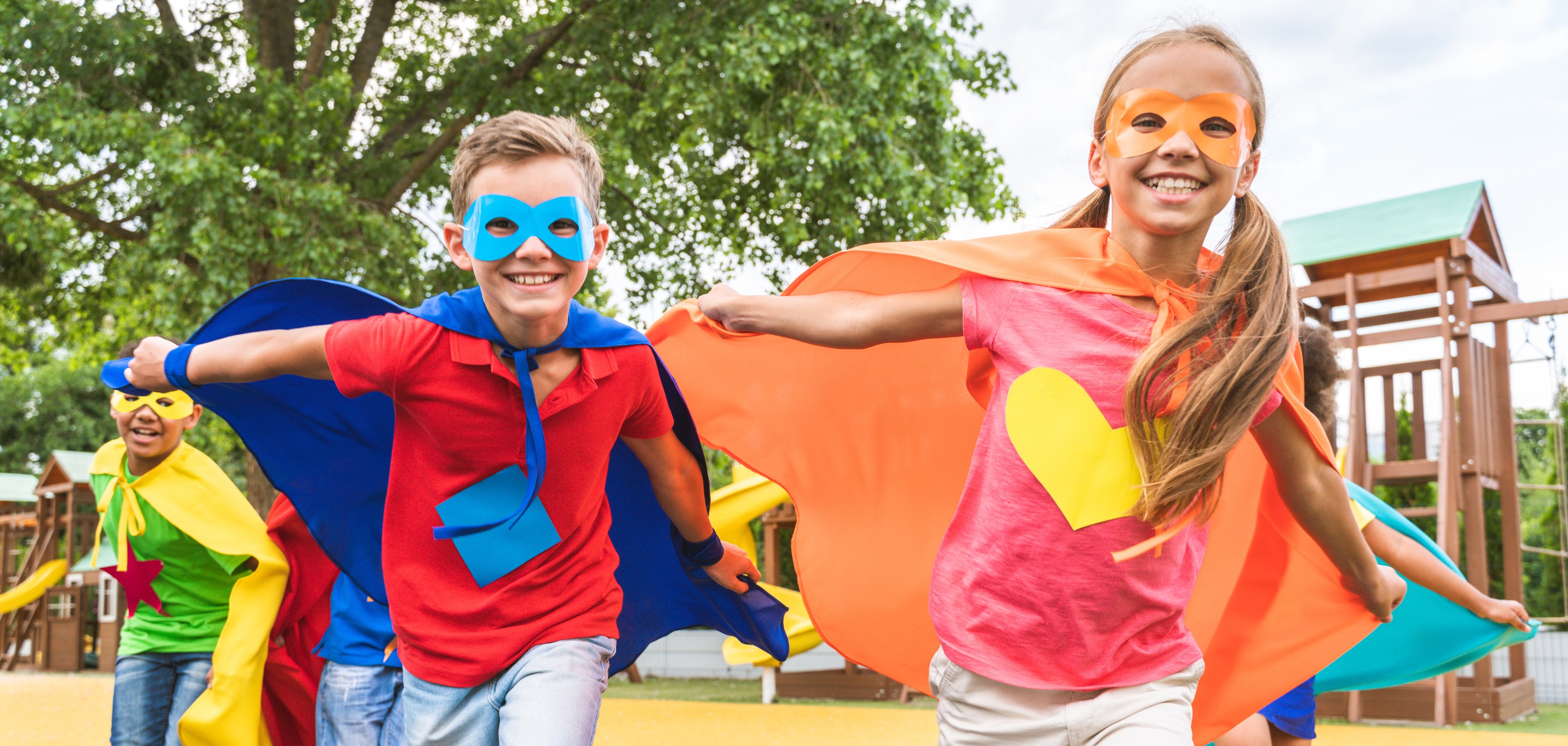 Group of young schooler wearing superhero costumes Ein Junge und ein Mädchen tragen farbenfrohe Superhelden Kostüme