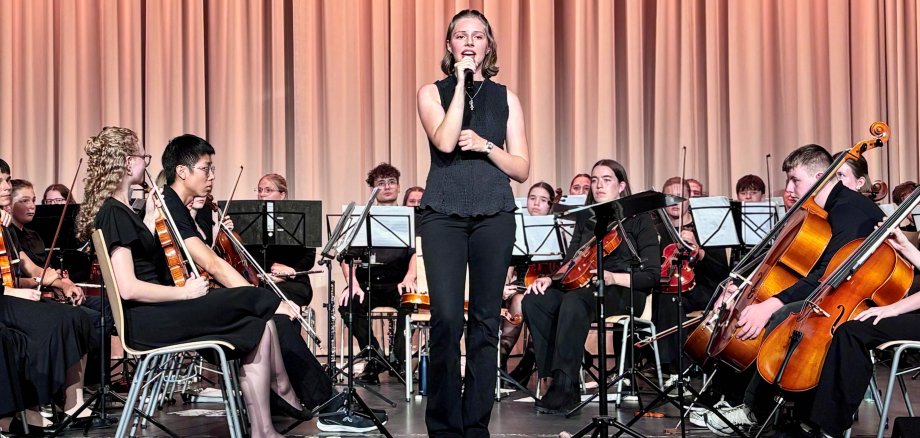 HGG Konzert Eine junge Frau singt auf einer Bühne