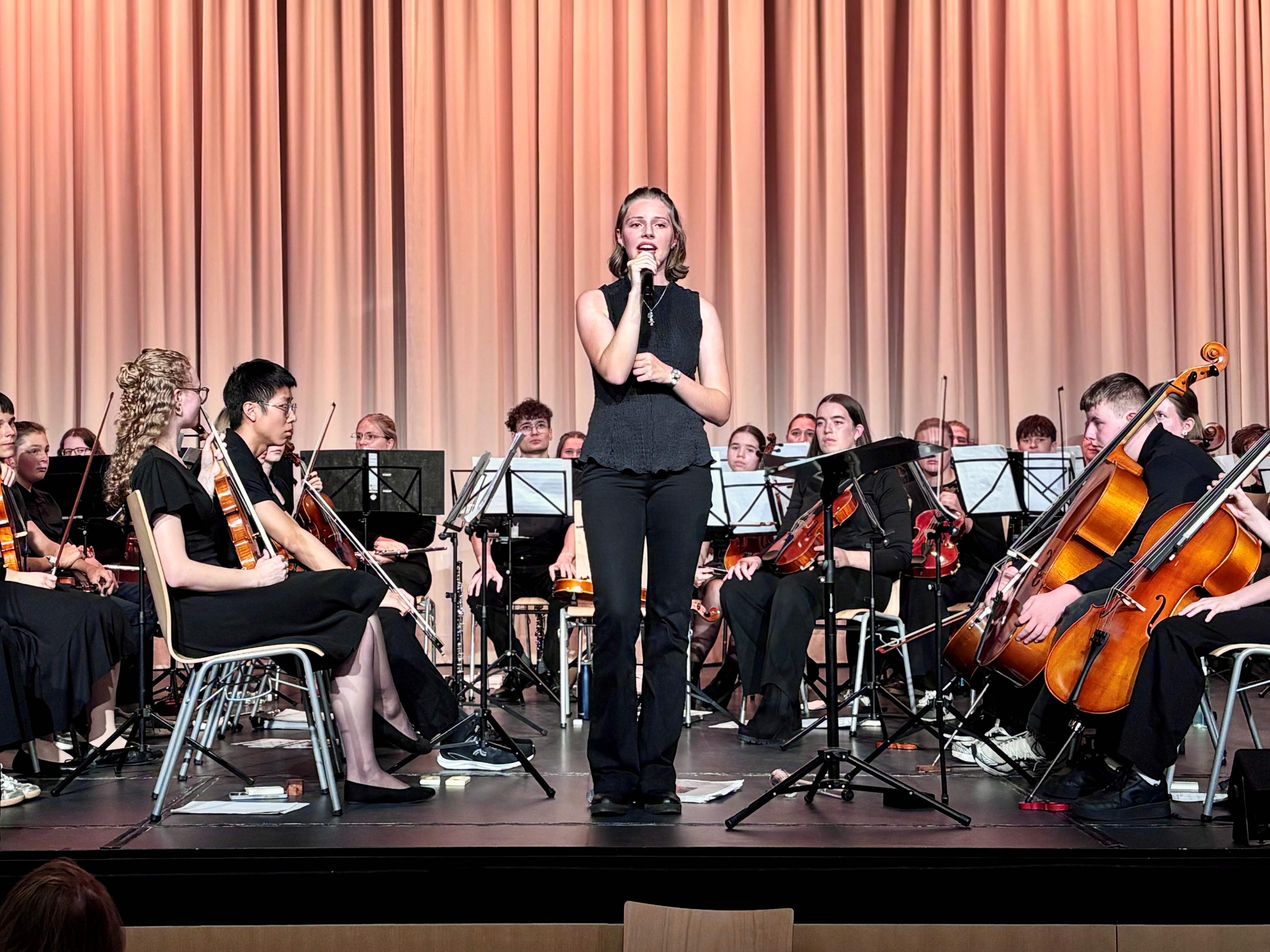 HGG Konzert Eine junge Frau singt auf einer Bühne