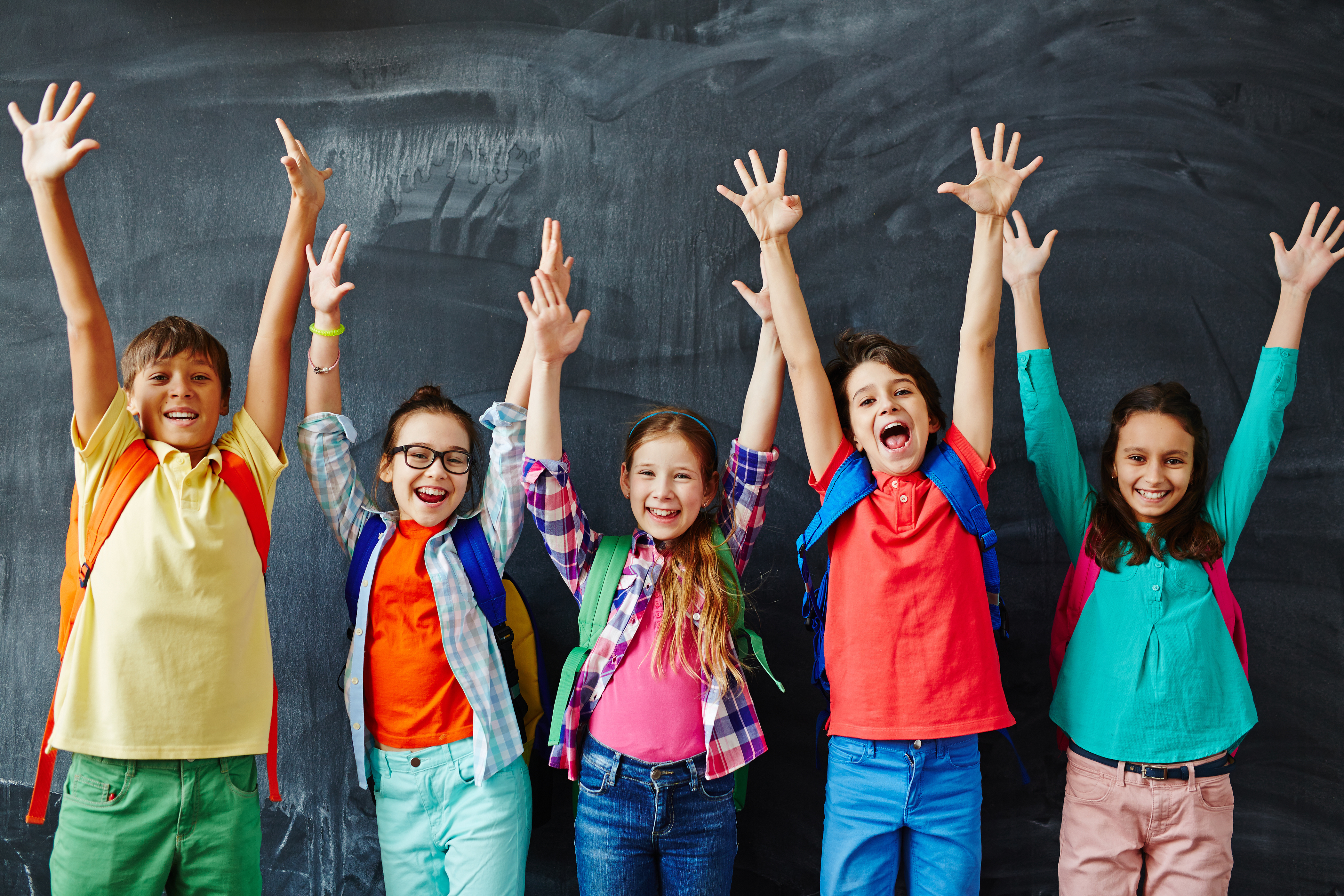 Happy schoolchildren Excited schoolchildren standing with hands up